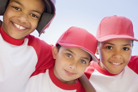 Multi-ethnic boys in baseball uniforms hugging