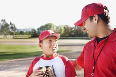 Hispanic baseball player and coach talking