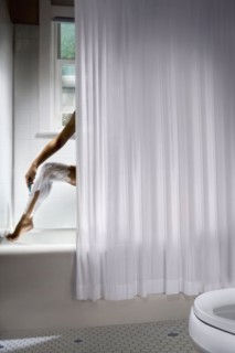 Korean woman shaving her legs in shower