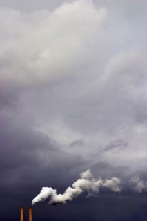 Overcast sky and smoke stacks billowing smoke