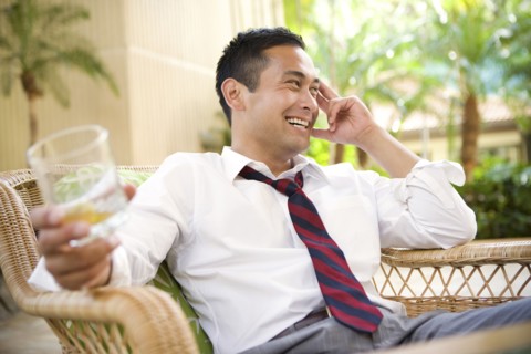 Smiling mixed race man drinking on patio