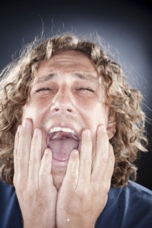 Caucasian man shouting with head in hands