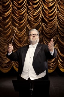 Caucasian conductor at podium