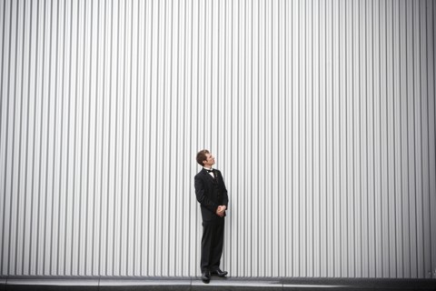 Uncertain groom standing near wall