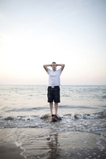 Caucasian woman standing on rock in ocean