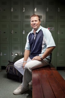 Caucasian man sitting on bench in locker room