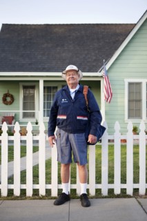 Caucasian mailman standing on sidewalk