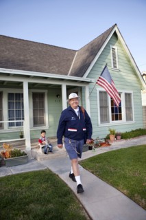Caucasian mailman walking in front yard