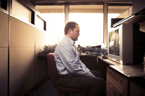 Caucasian businessman watching television at desk