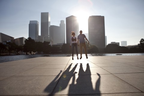 Couple casting shadows on urban waterfront