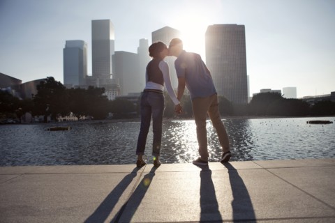 Couple casting shadows on urban waterfront