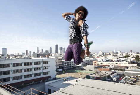 African American man jumping for joy on urban rooftop