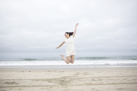 Woman jumping for joy on beach