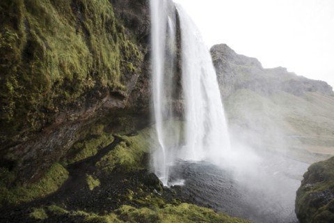 Waterfall over rock formation cliffs