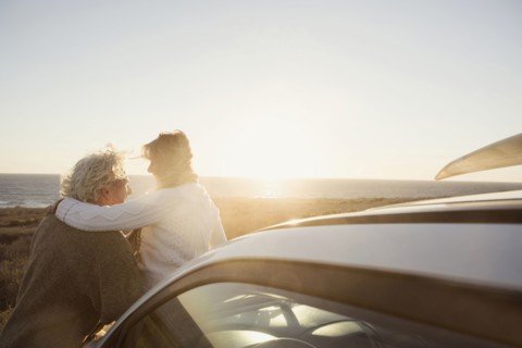 Older Caucasian couple hugging outdoors