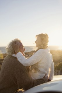 Older Caucasian couple hugging outdoors