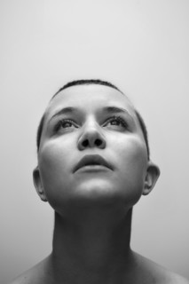 Caucasian woman with shaved-head looking up