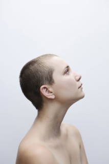 Caucasian woman with shaved-head looking up