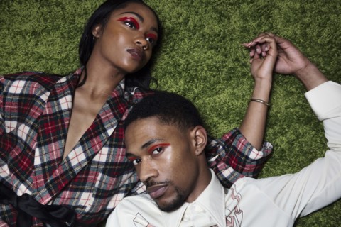Couple laying on grass holding hands