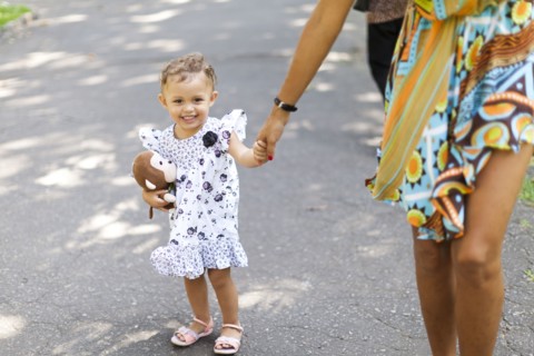 Mother and daughter walking on sidewalk