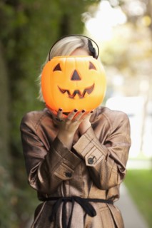 Caucasian woman holding jack o' lantern bucket