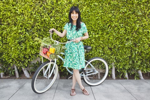 Woman carrying produce in bicycle basket