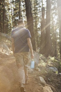 Man hiking on dirt trail in forest