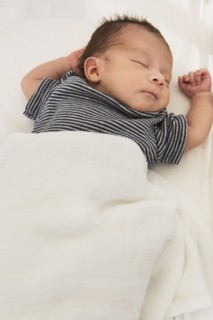 Mixed race baby sleeping on bed