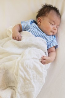 Mixed race baby sleeping in bed