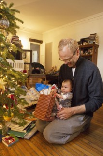 Father and baby boy opening Christmas gifts