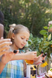 Girl picking flowers and berries in backyard