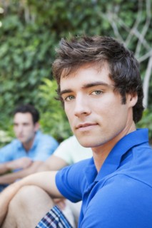 Close up of serious man sitting in backyard