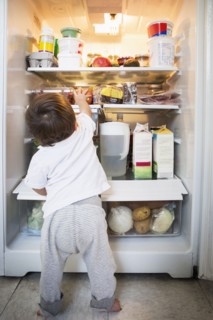 Mixed race baby boy exploring refrigerator