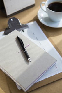 Tablet computer on table with books and cup of coffee
