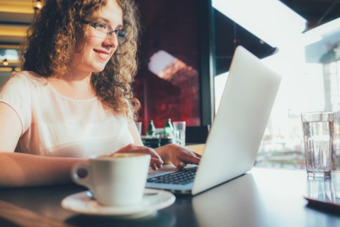 Woman using laptop computer in cafe