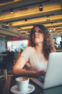 Woman using laptop computer in cafe