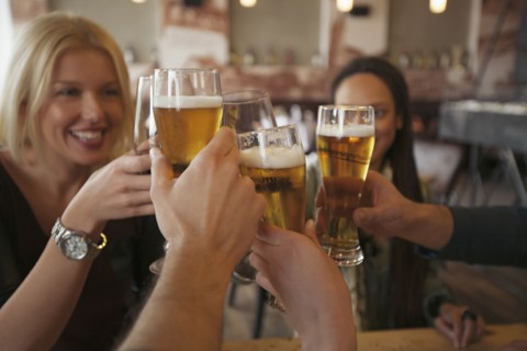 Friends toasting with beer in cafe