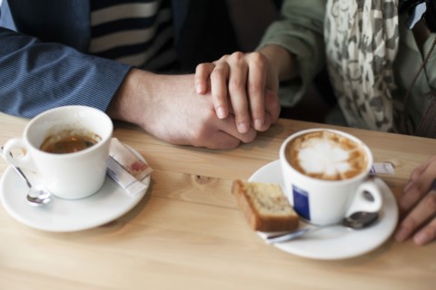 Couple holding hands in cafe