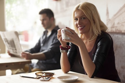 Woman drinking cup of coffee in cafe