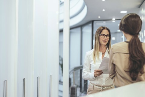 Caucasian businesswoman talking in office corridor
