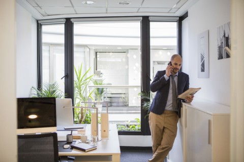 Caucasian businessman talking on cell phone in office