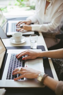 Caucasian businesswomen working at laptops at desk