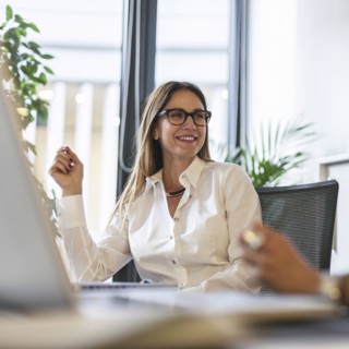 Caucasian businesswoman smiling at desk in office
