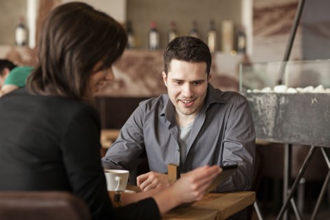Couple using cell phone in cafe