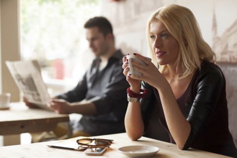 Woman drinking cup of coffee in cafe