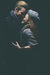 Smiling couple wearing warm clothing hugging