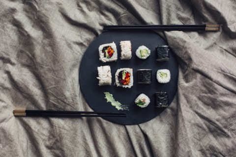 Close up of sushi platter with chopsticks in bed
