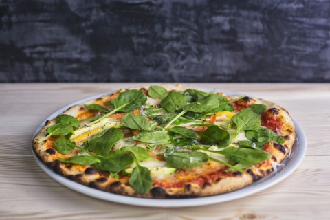Close up of pizza with fresh spinach
