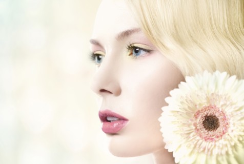 Caucasian woman with pink lipstick wearing white flower