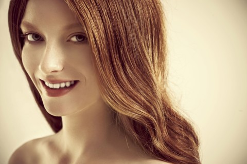 Close up of smiling woman with long red hair